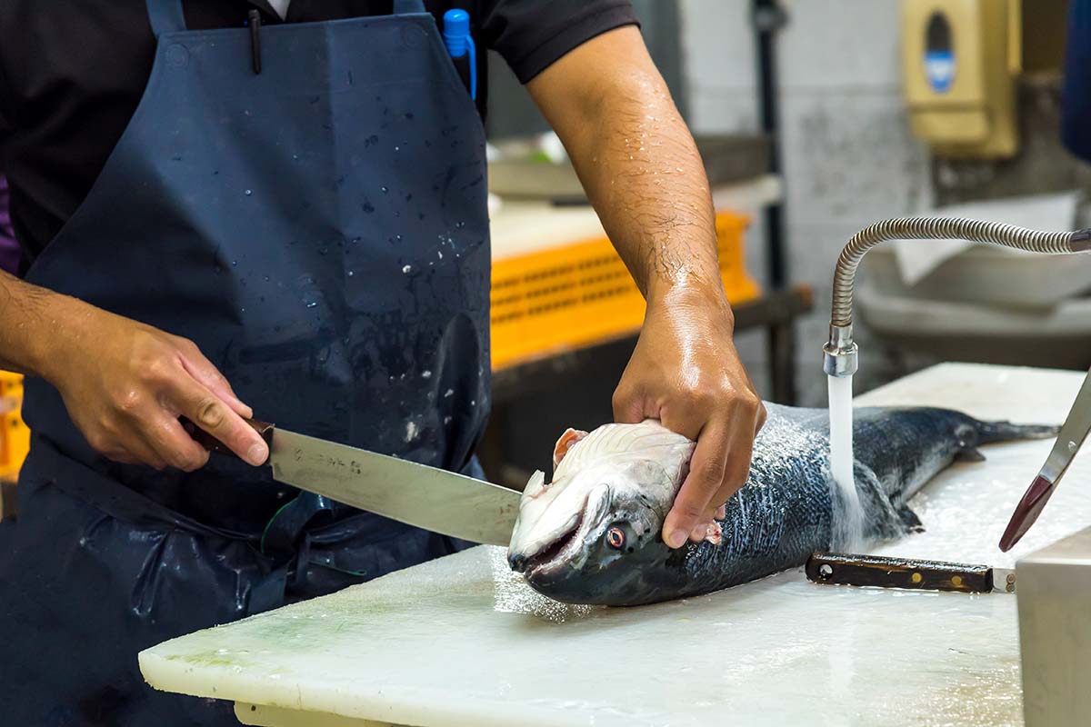 職人が丁寧に魚の切り身を加工している様子
